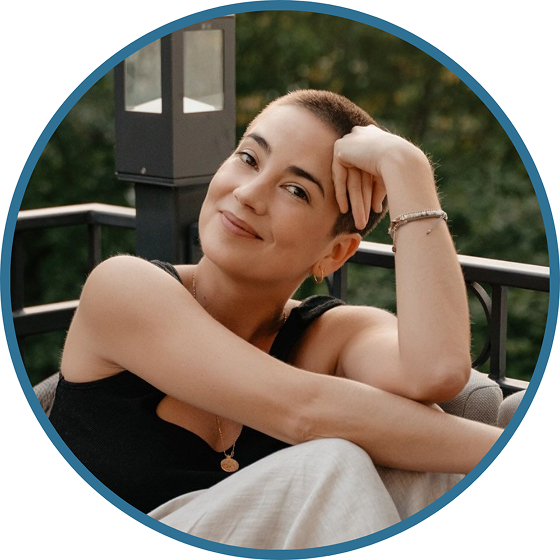 Xenia - did the facilitator training in Bali - seen with arms leaning on knees smiling to camera