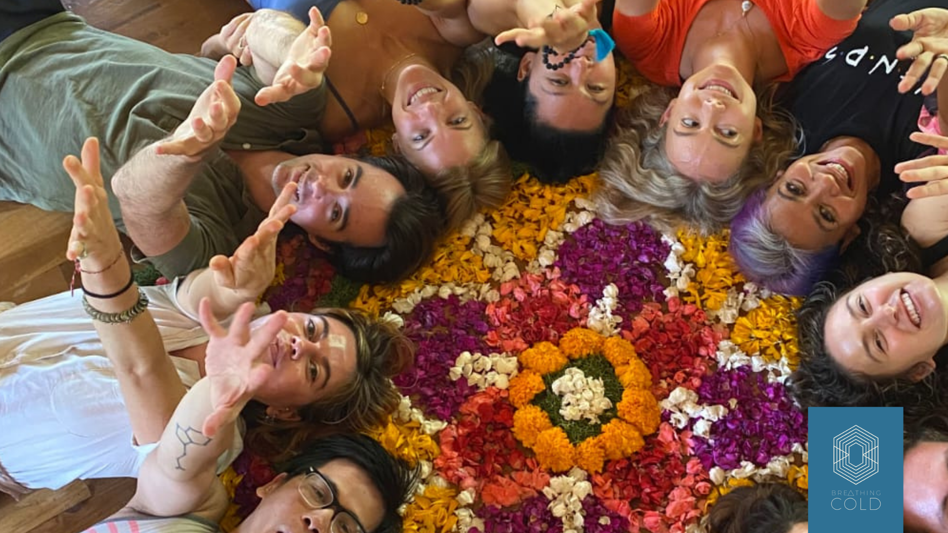 group of humans, laying on flowers pointing towards the camera